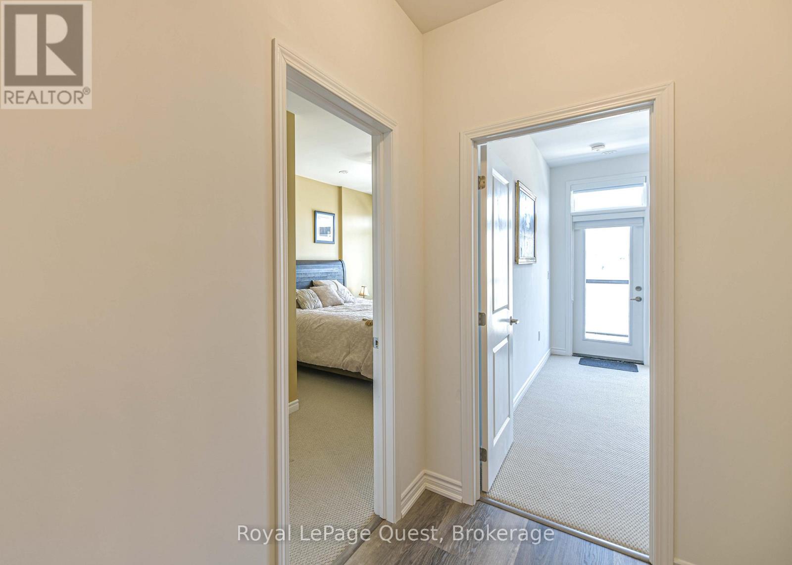 A bedroom with a bed and a doorway leading to another room.