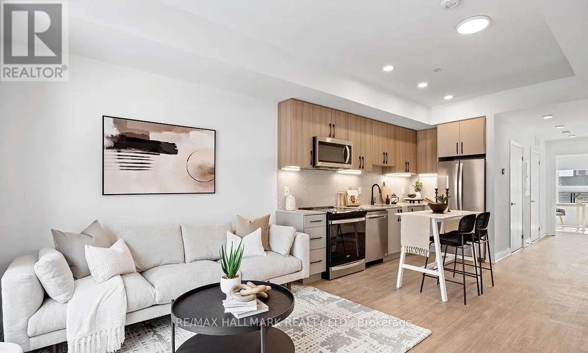 A modern living room with a white sofa and a kitchen area in the background.
