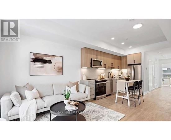 A modern living room with a white sofa and a kitchen area in the background.