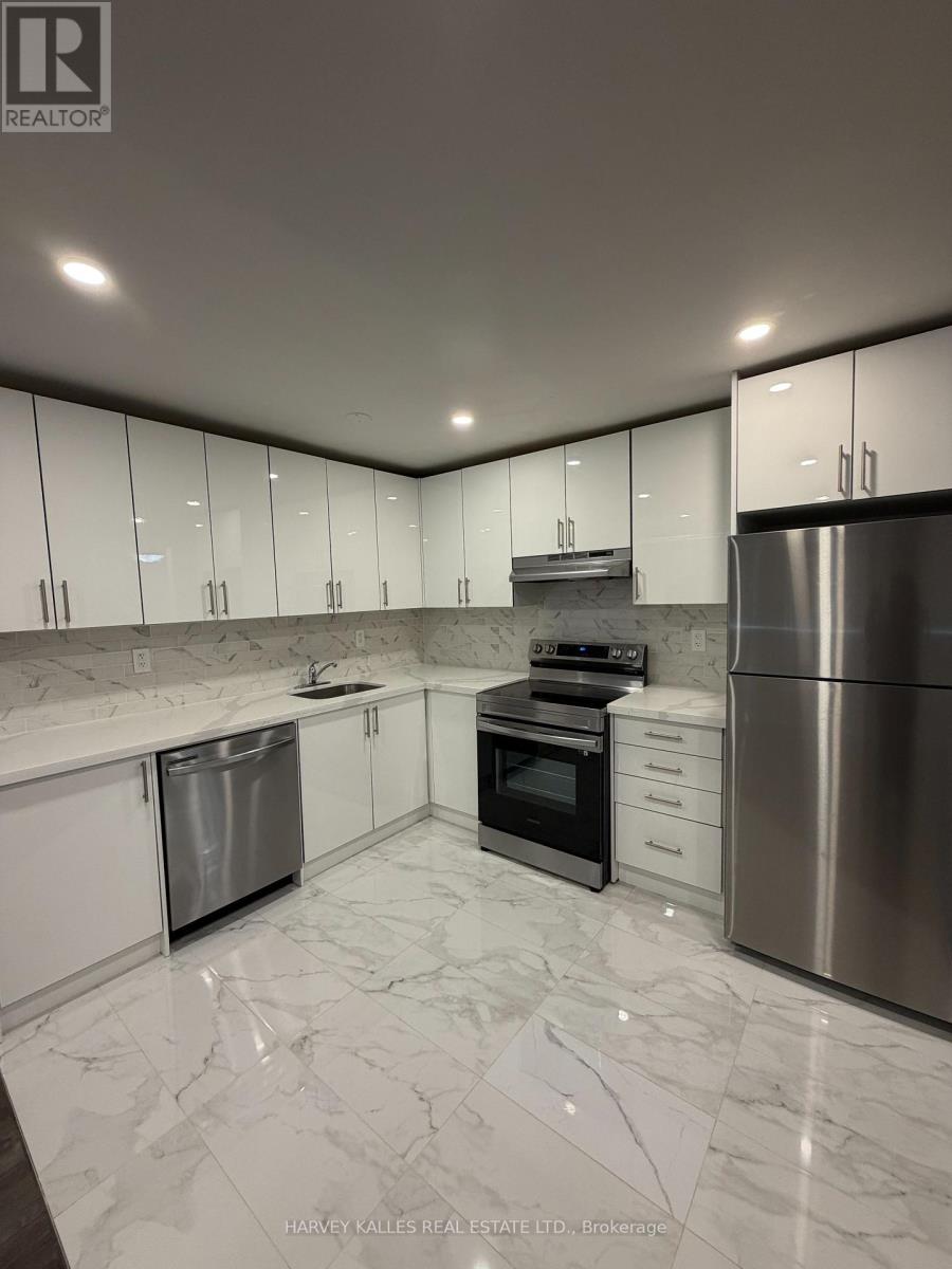 A modern kitchen with stainless steel appliances and white marble countertops.