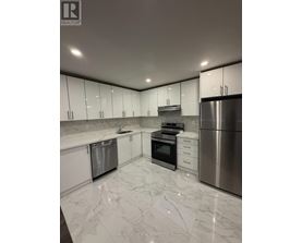 A modern kitchen with stainless steel appliances and white marble countertops.