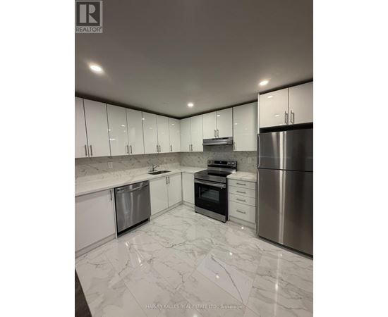A modern kitchen with stainless steel appliances and white marble countertops.