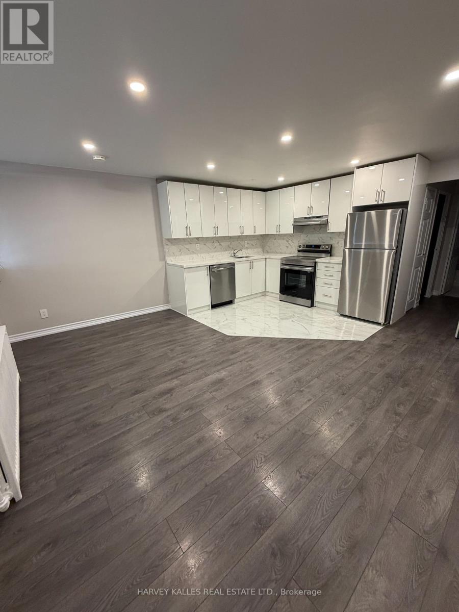 A spacious kitchen with wood flooring and stainless steel appliances.