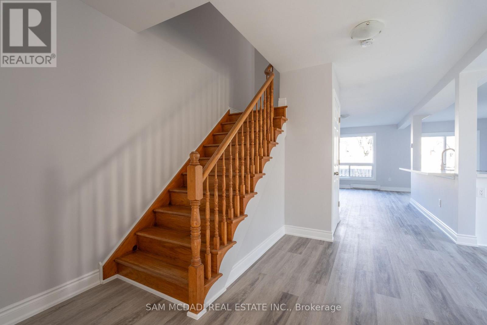 A wooden staircase leads up to a brightly lit room.