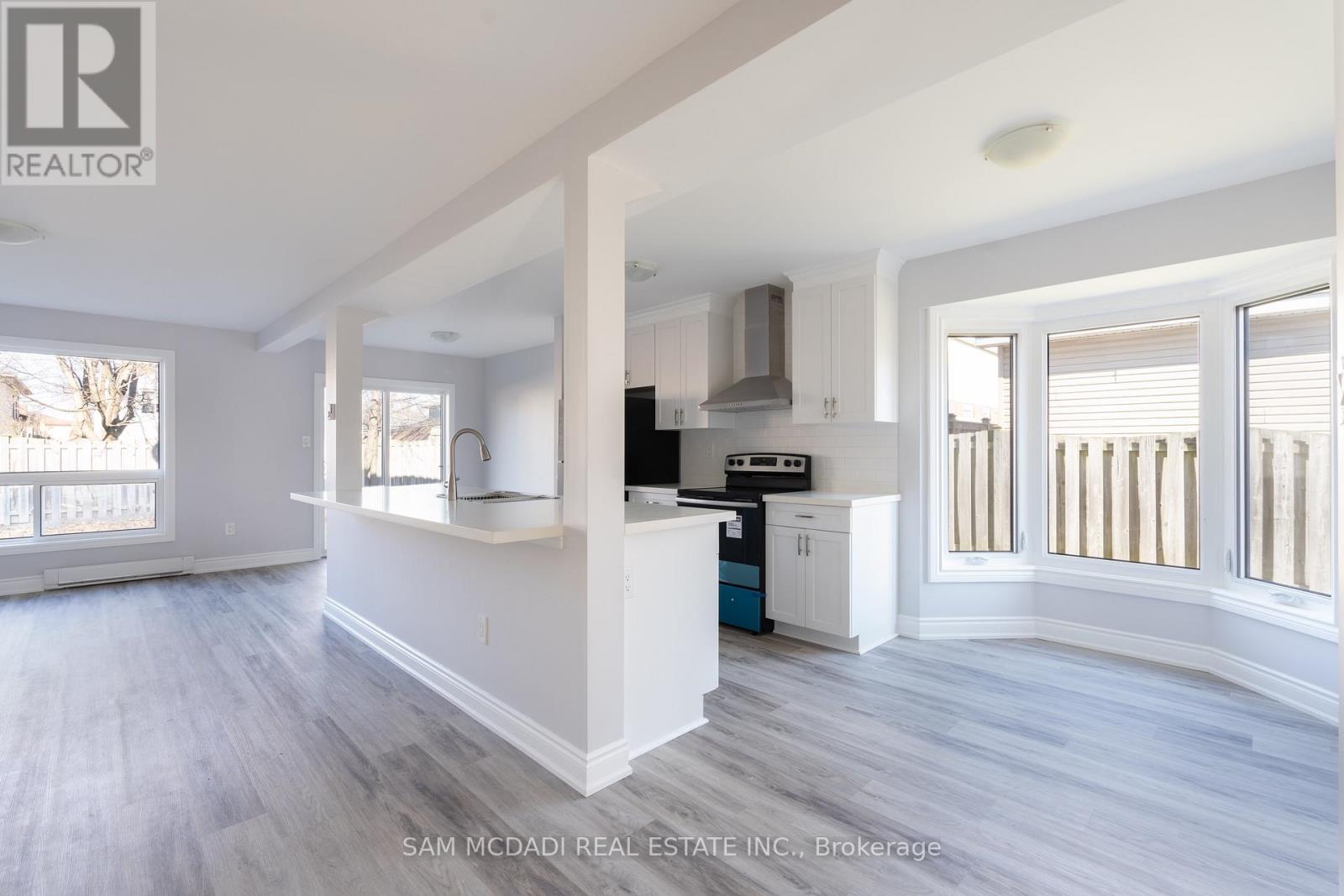A real estate listing image of a kitchen and living room.