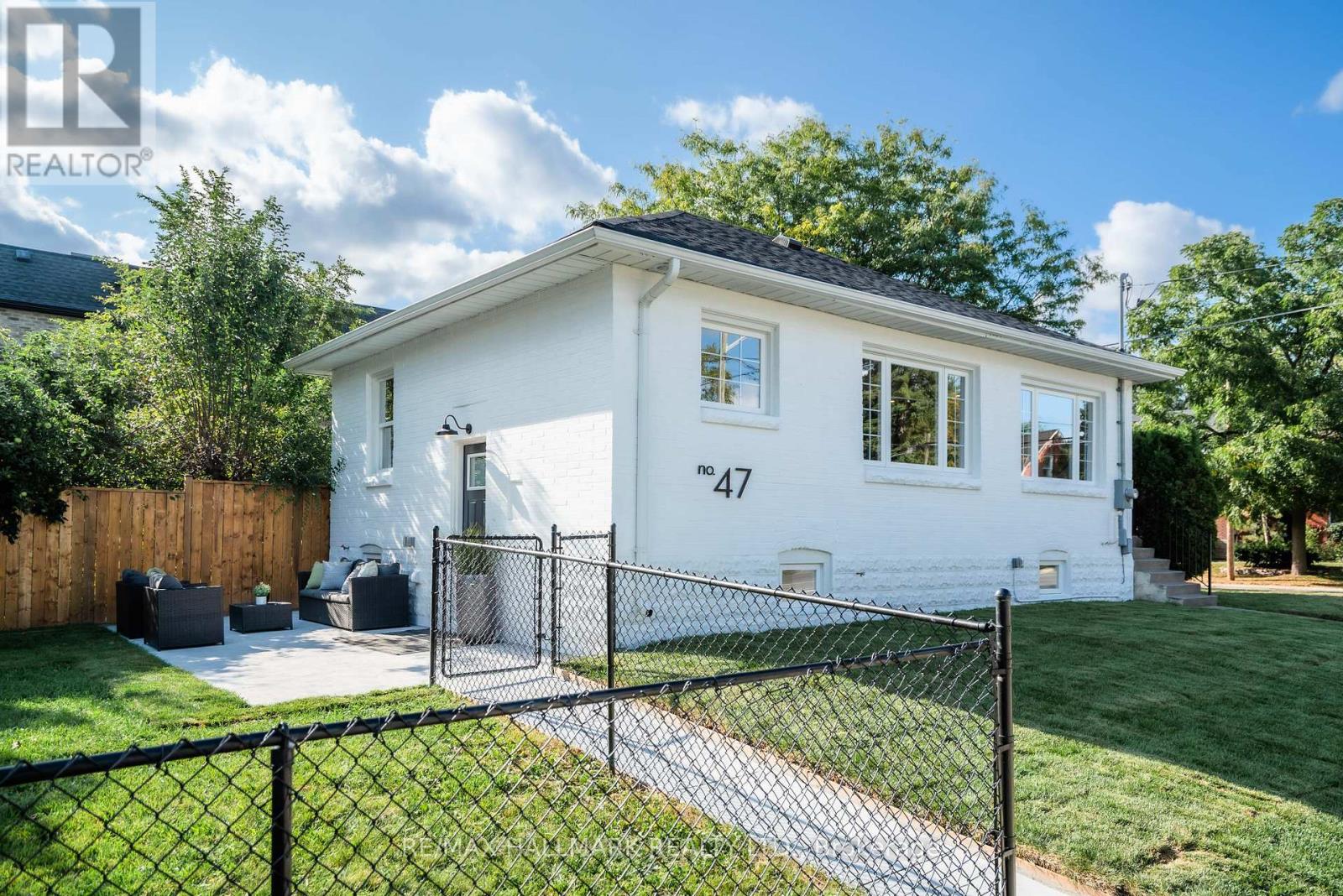 A white house with a black fence in front of it.