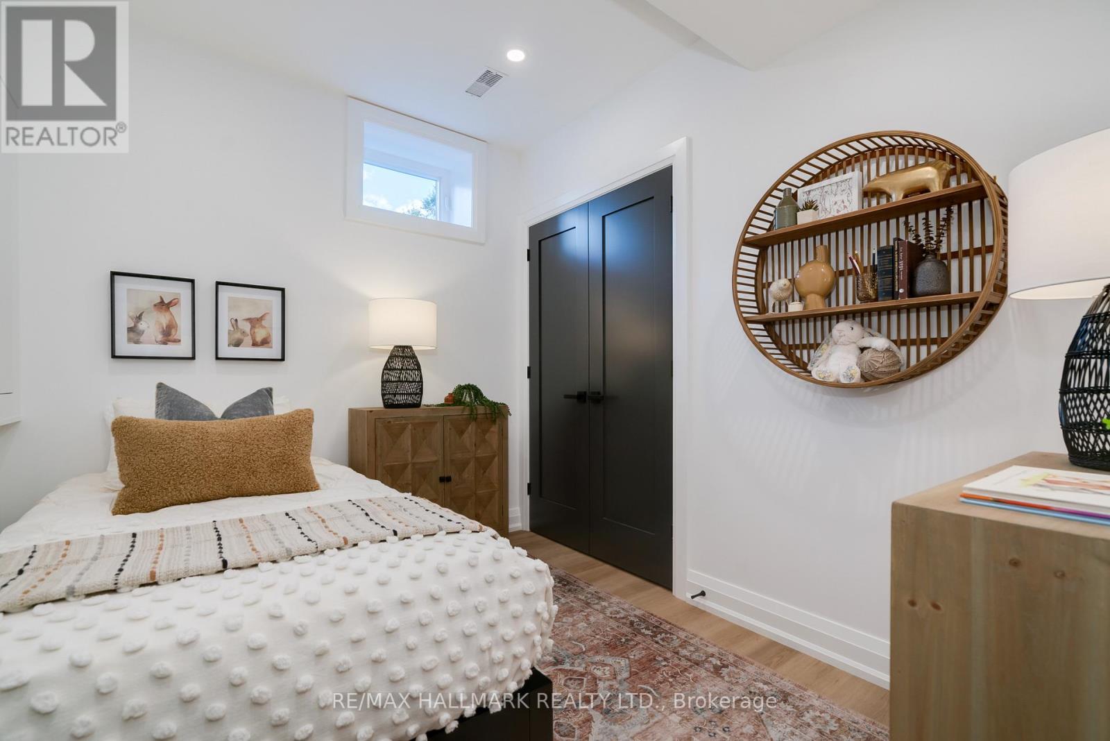 A bedroom with a white bed and a wooden headboard.