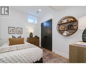 A bedroom with a white bed and a wooden headboard.