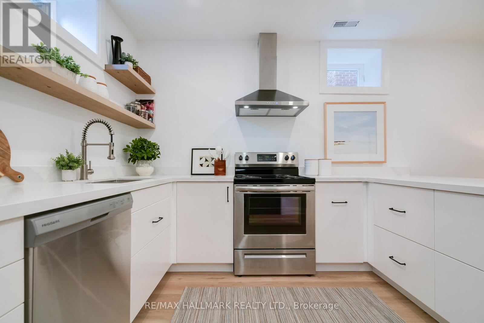 A modern kitchen with white cabinets and stainless steel appliances.