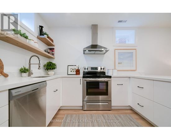 A modern kitchen with white cabinets and stainless steel appliances.