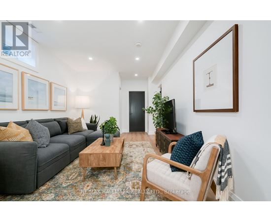 A living room with a grey couch, a wooden coffee table, and a large painting on the wall.