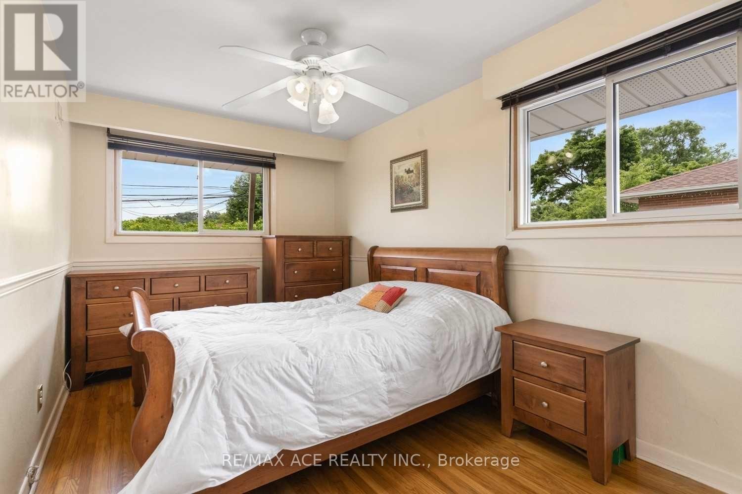 A bedroom with a bed, nightstand, and window.