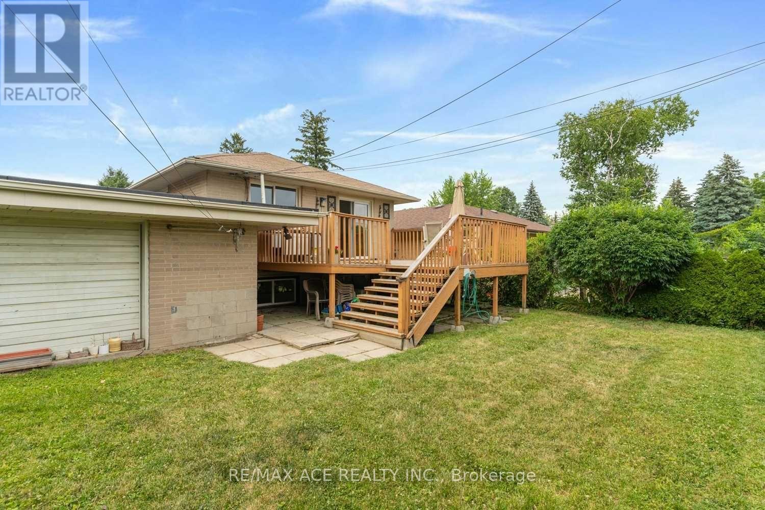 A house with a wooden deck and stairs leading to the entrance.