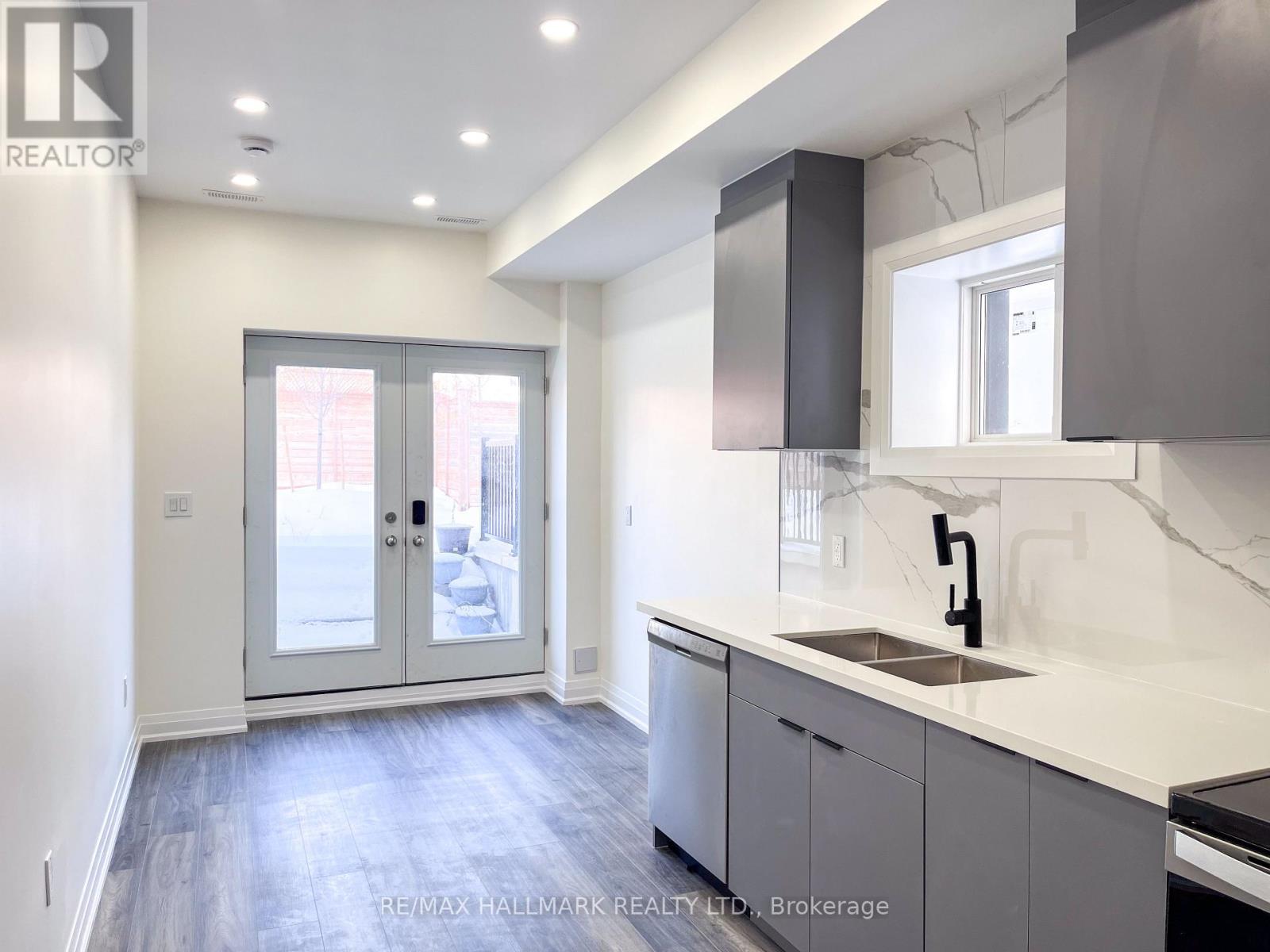 A modern kitchen with a sink, cabinets, and a window.
