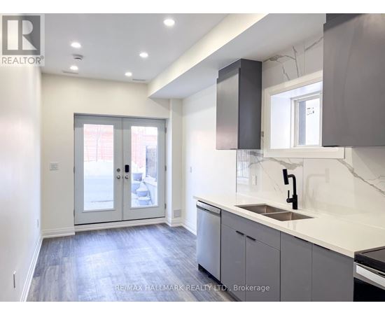 A modern kitchen with a sink, cabinets, and a window.