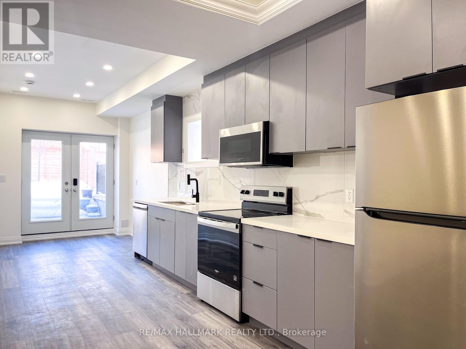 A modern kitchen with stainless steel appliances and white cabinetry.