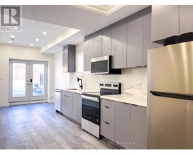 A modern kitchen with stainless steel appliances and white cabinetry.
