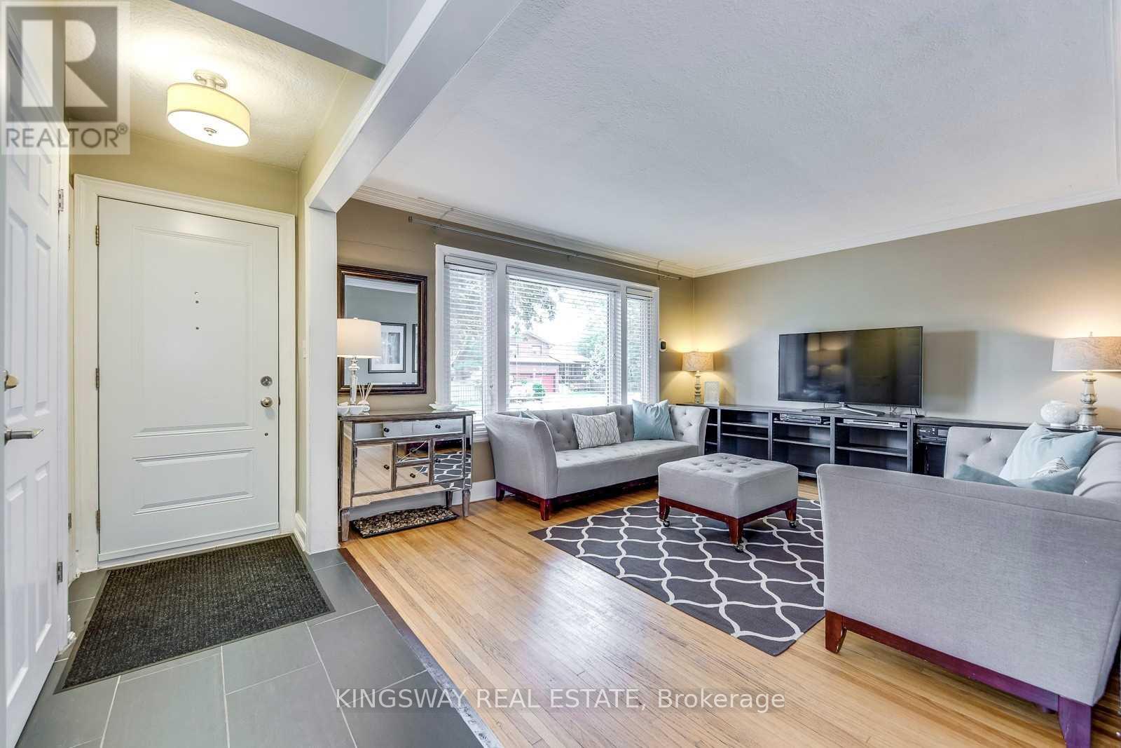 A living room with a grey couch and a black and white rug.