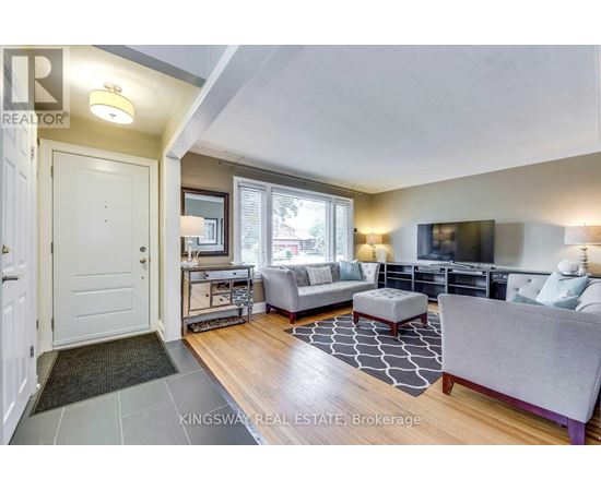 A living room with a grey couch and a black and white rug.