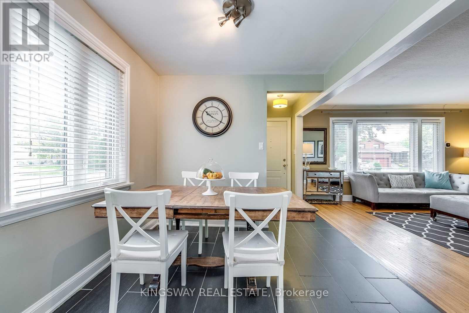 A dining room with a table set for two and a couch in the background.