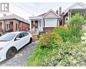 A white car is parked in front of a house.