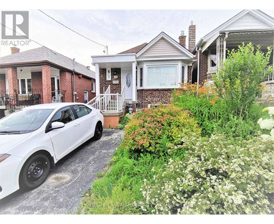 A white car is parked in front of a house.