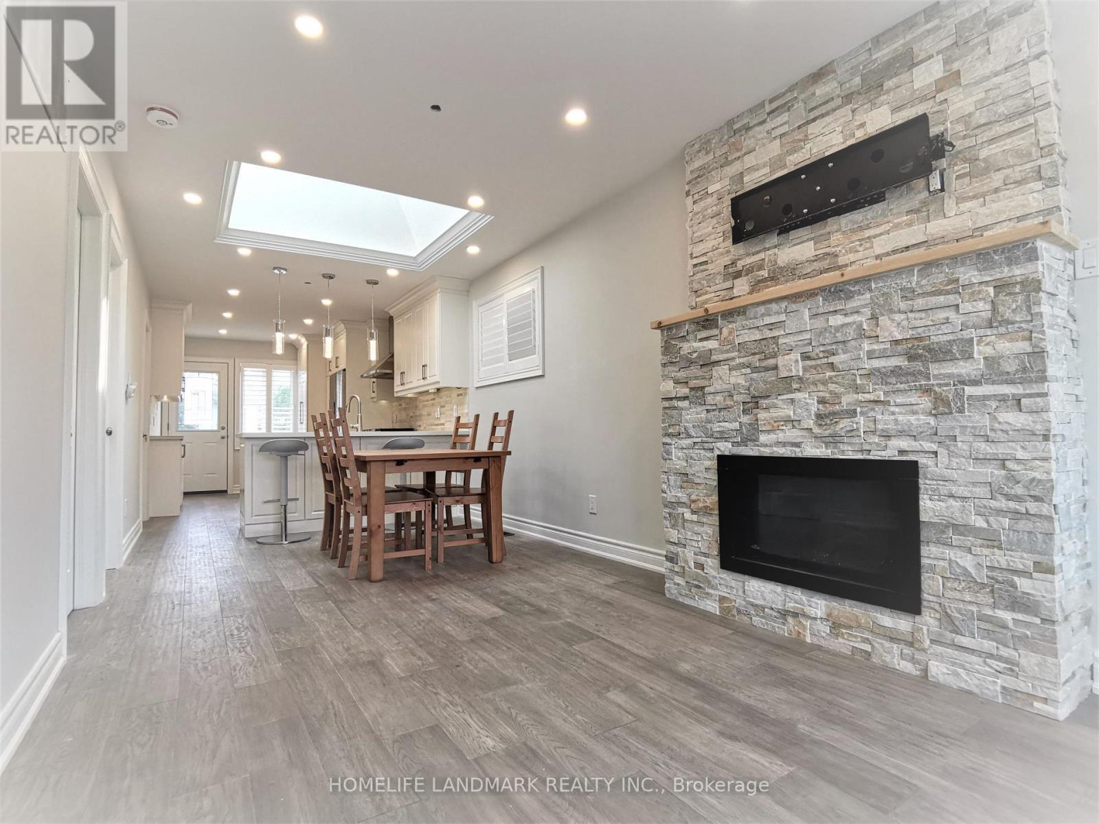 A stone fireplace is built into a wall in a spacious room.