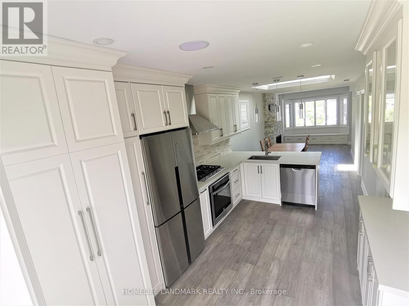 A kitchen with white cabinets and a black fridge.