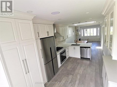 A kitchen with white cabinets and a black fridge.