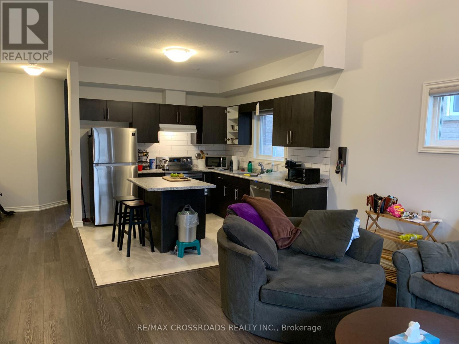A kitchen with a refrigerator, stove, and microwave.