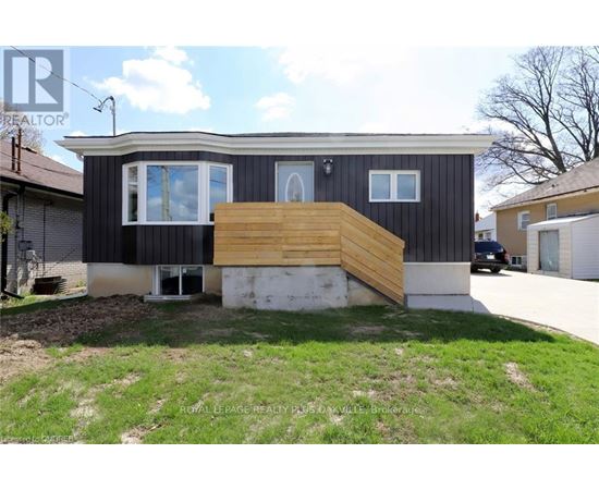 A house with a black exterior and a wooden deck in front.
