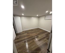 A room with wooden flooring and white walls.