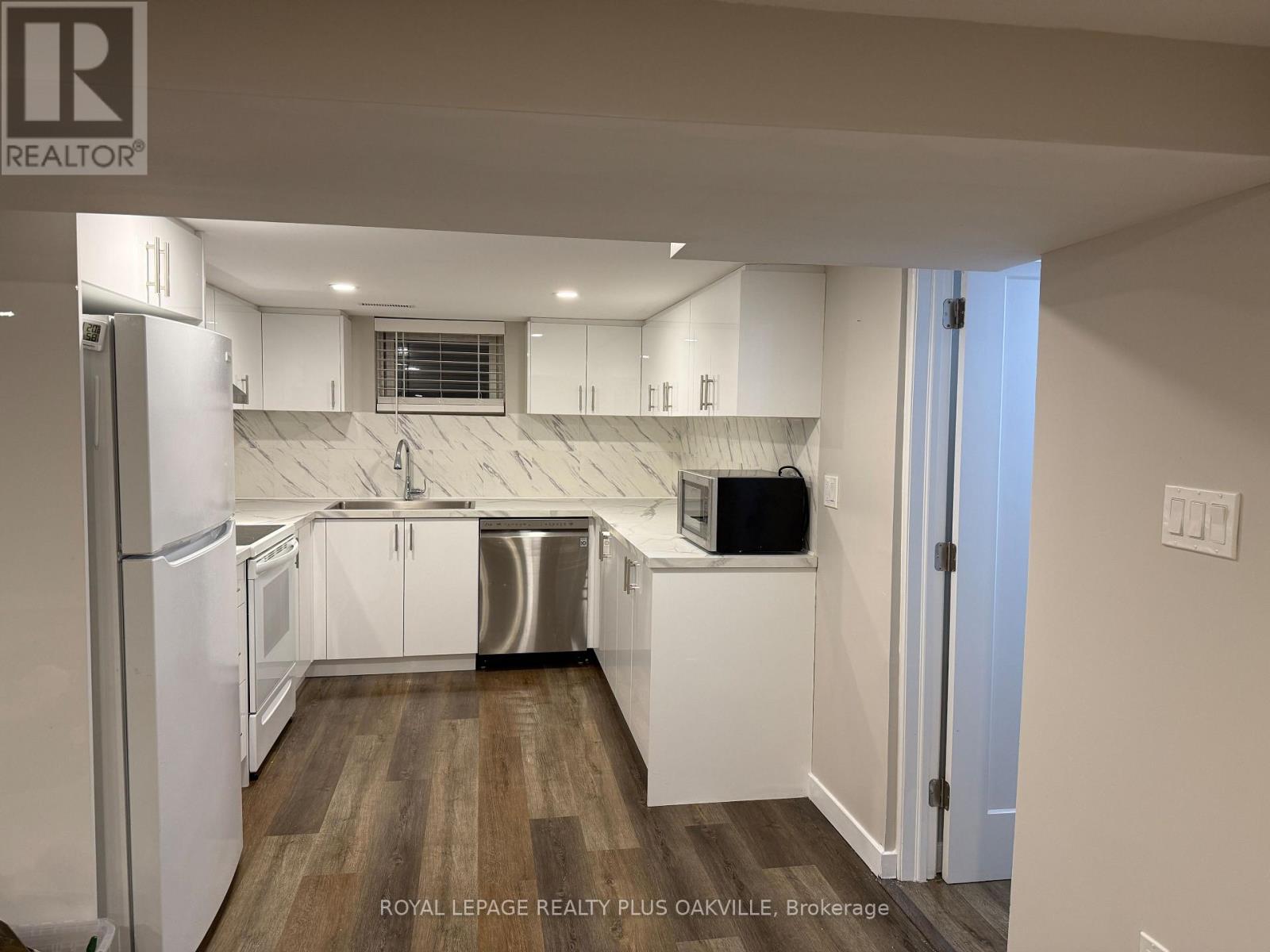 A kitchen with white cabinets and a refrigerator.