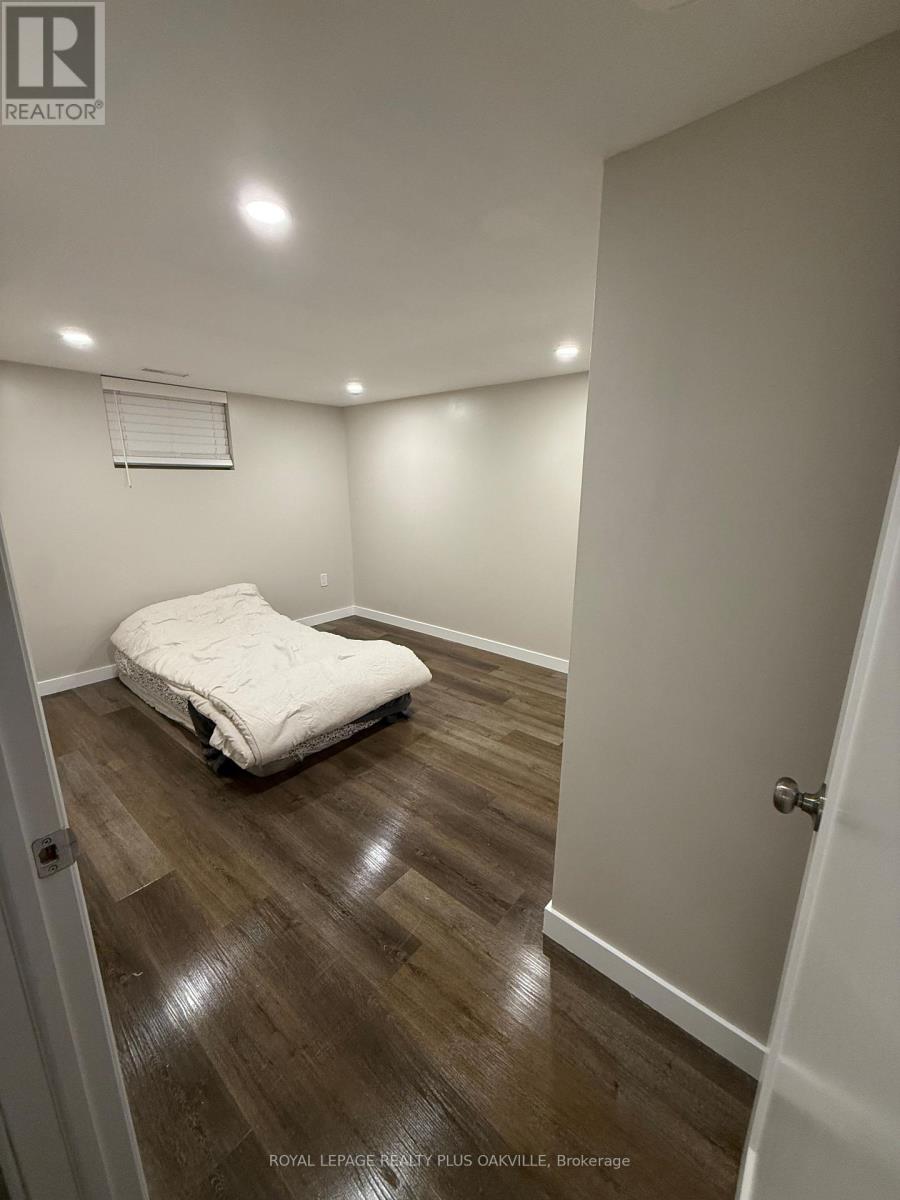 A bedroom with a bed and wooden floors.