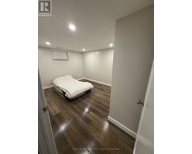 A bedroom with a bed and wooden floors.