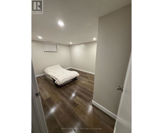A bedroom with a bed and wooden floors.