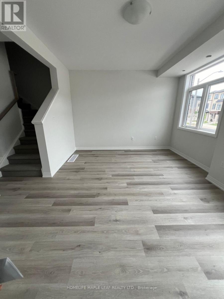 A room with wooden flooring and a staircase.