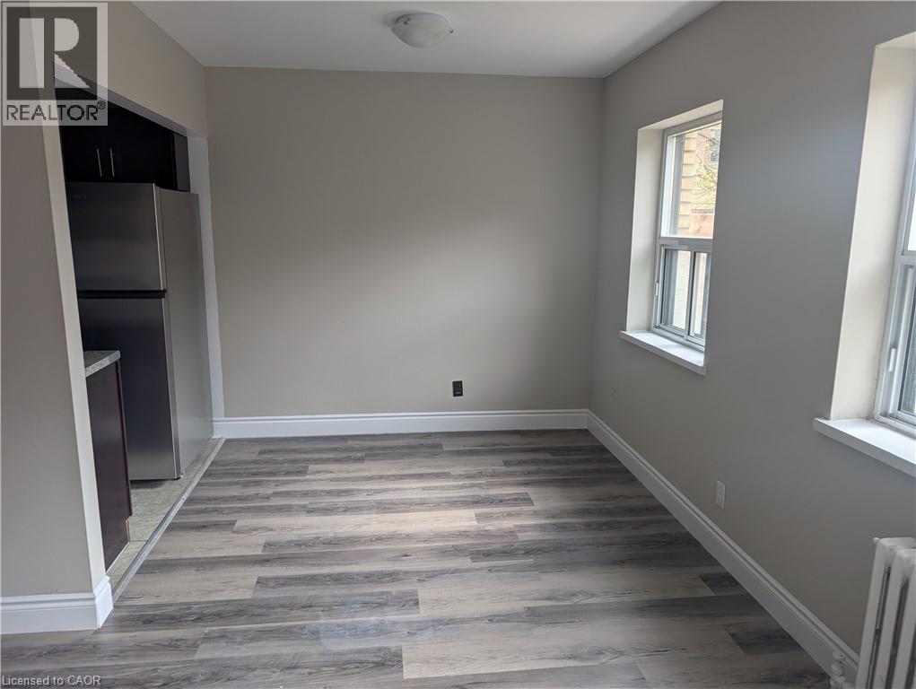 A room with wooden flooring and a window on the right side.