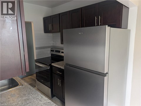 A kitchen with a stainless steel refrigerator and oven.