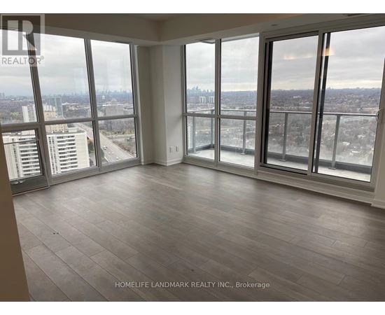 A large, empty room with a view of the cityscape outside the windows.