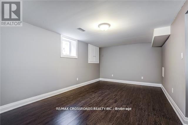 A room with a window and a wooden floor.