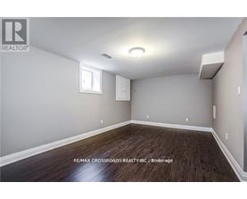 A room with a window and a wooden floor.
