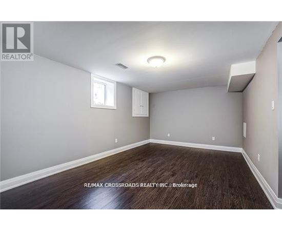 A room with a window and a wooden floor.