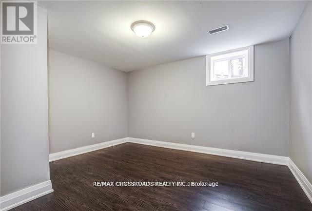 A room with a window and a wooden floor.