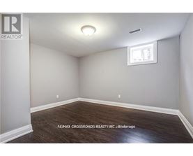 A room with a window and a wooden floor.
