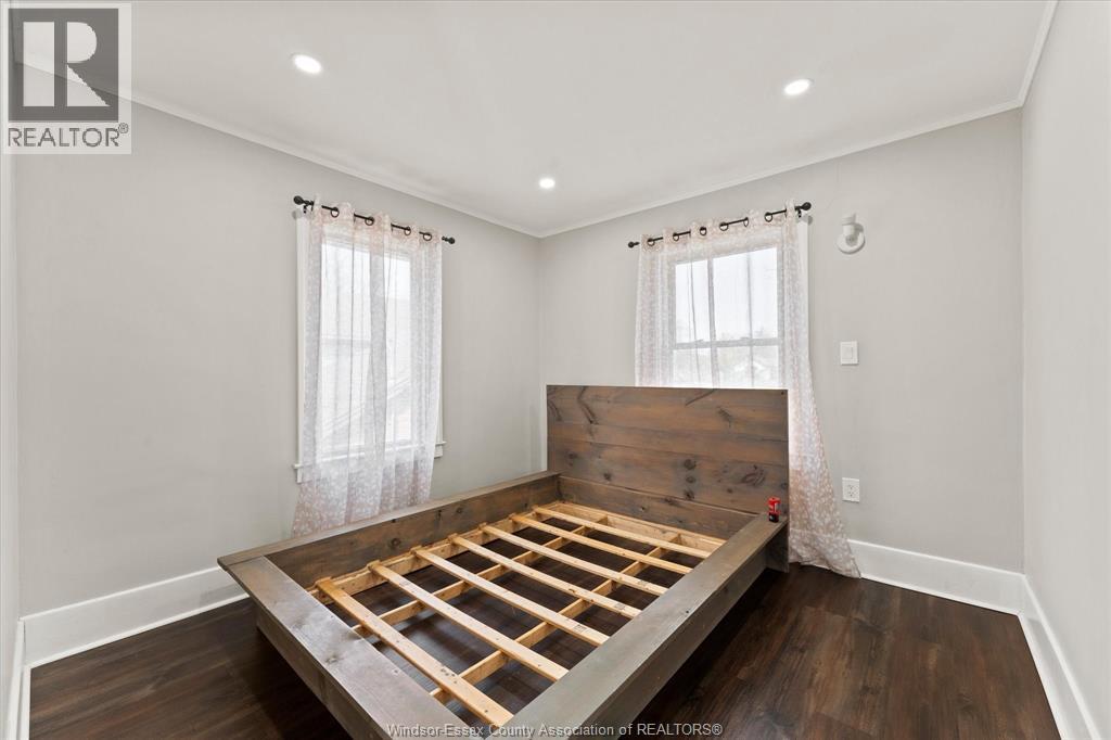 A bedroom with a wooden headboard and a bed in the middle.