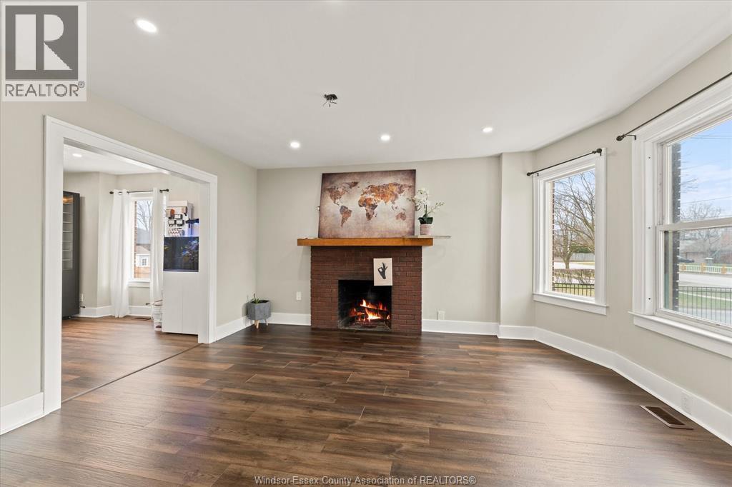 A spacious living room with a fireplace and a painting above it.