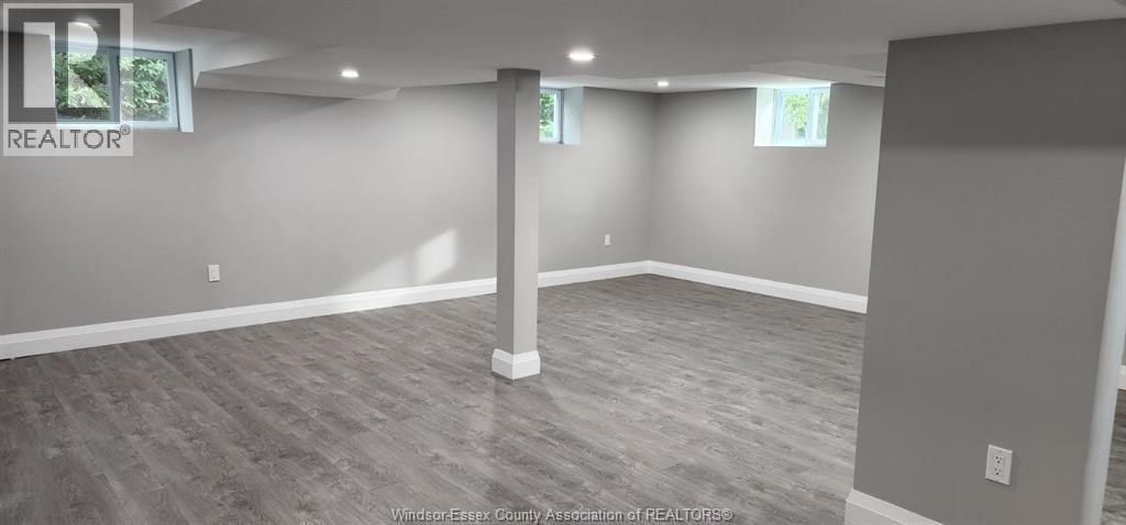 A spacious room with a grey floor and walls, and a pillar in the middle.