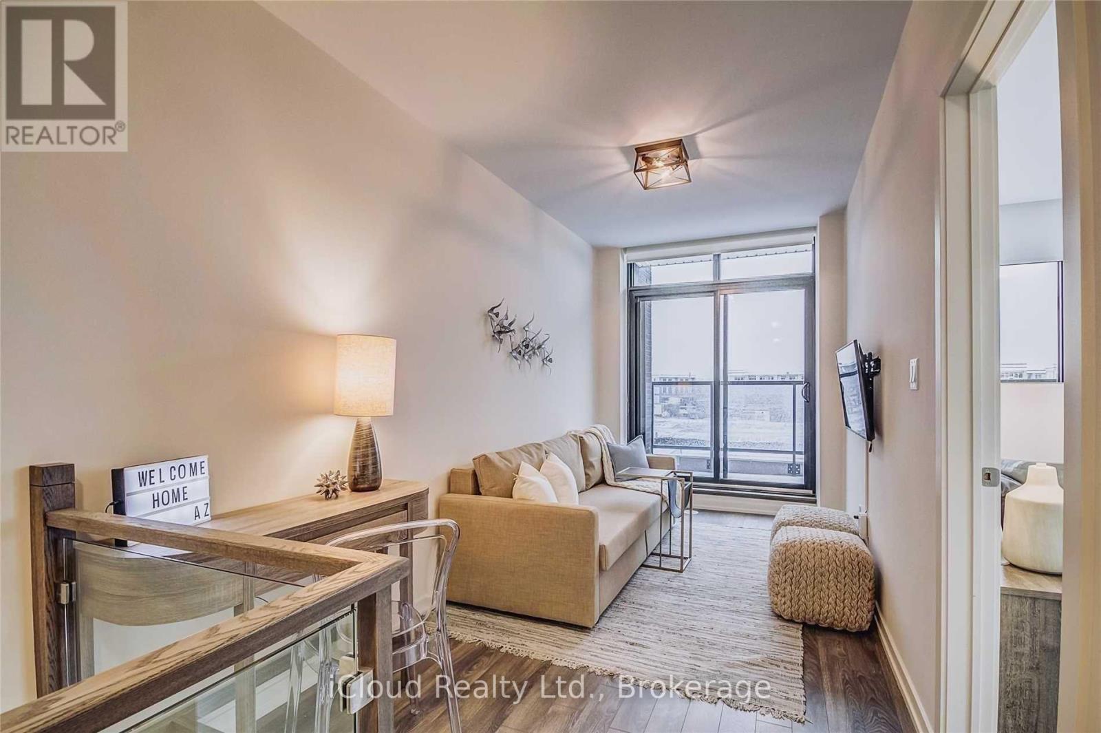 A living room with a glass table, a sofa, a chair, and a sign that says "Welcome Home".