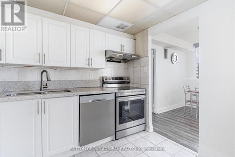 A kitchen with white cabinets and a stainless steel oven.